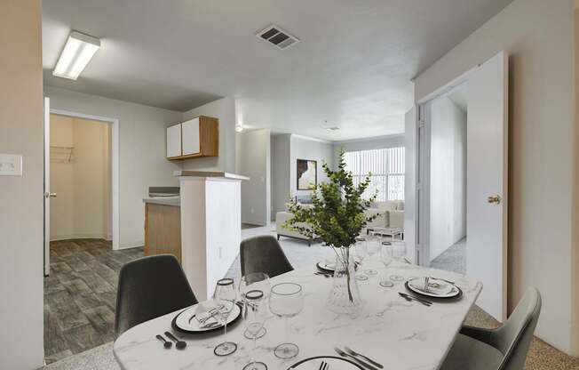 A dining room with a table set for two with a plant in the middle.