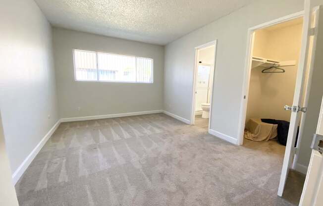 an empty room with a closet and a window