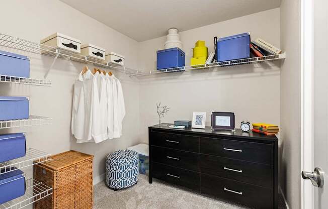 A white shirt is hanging on a rack in a bedroom.