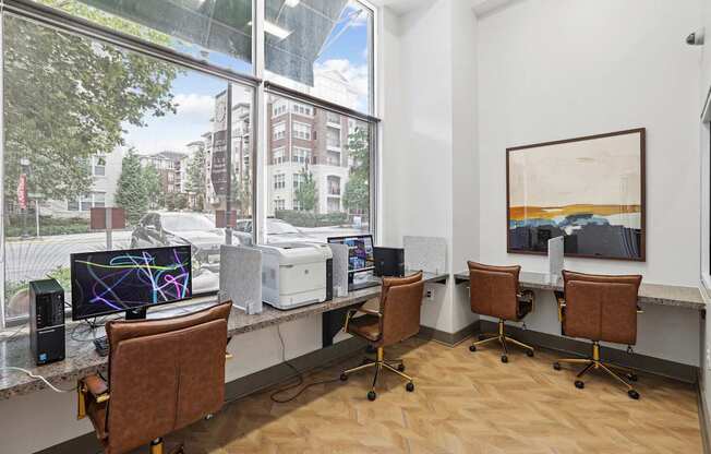 A room with a desk, chairs, and a computer monitor.