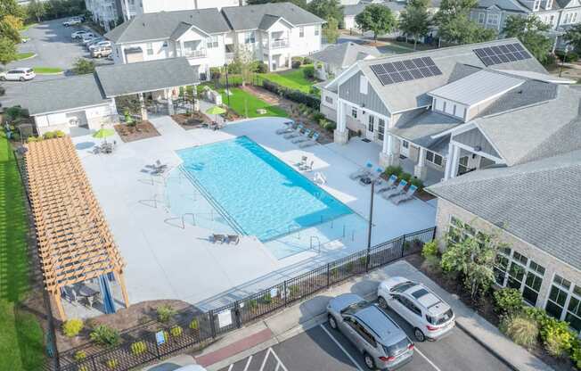 an aerial view of a swimming pool in front of a house