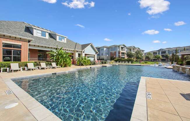 A swimming pool in a residential area with houses in the background.