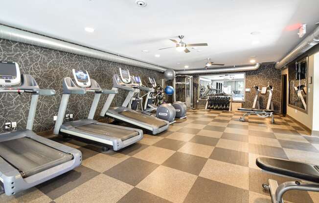 a spacious fitness room with treadmills and other exercise equipment