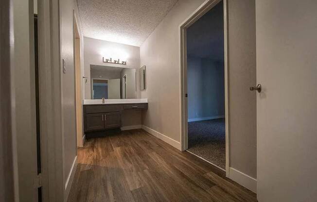 a bathroom with a sink and a large mirror at Aspire Upland Apartments, Upland, California