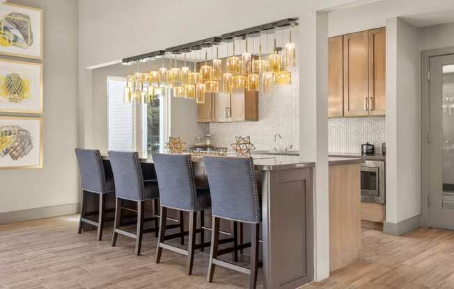 a kitchen with a bar with chairs and a chandelier at South Lamar Village, Texas, 78704