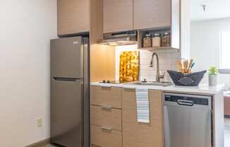 a small kitchen with stainless steel appliances and wooden cabinets
