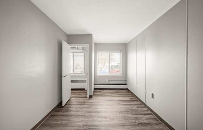 an empty room with white walls and a wood floor