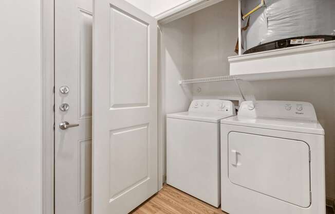 Apartments in San Marcos-Sadler House-Laundry Room- White Washer and Dryers, Wood-Style Floors, and Storage Space