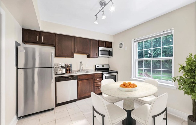 a kitchen with stainless steel appliances and a table with chairs