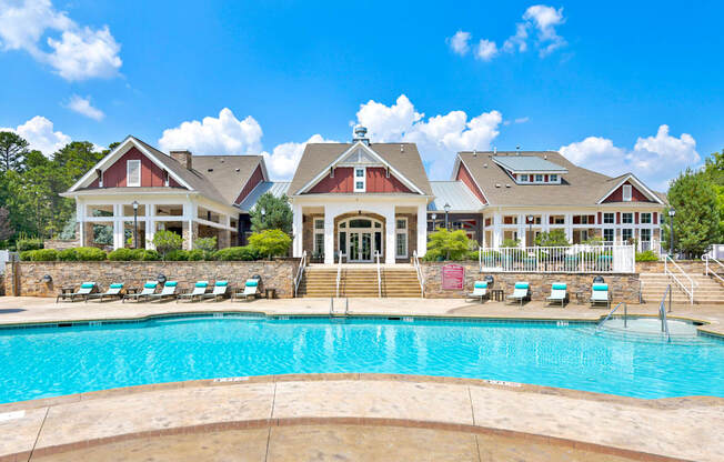 a large swimming pool with a house in the background