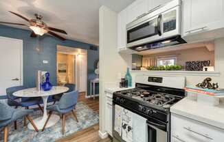 Kitchen and Dining Area with Stainless Steel Appliances and Hardwood Inspired Floors