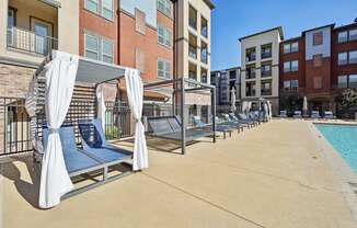 A pool area with sun loungers and a canopy.