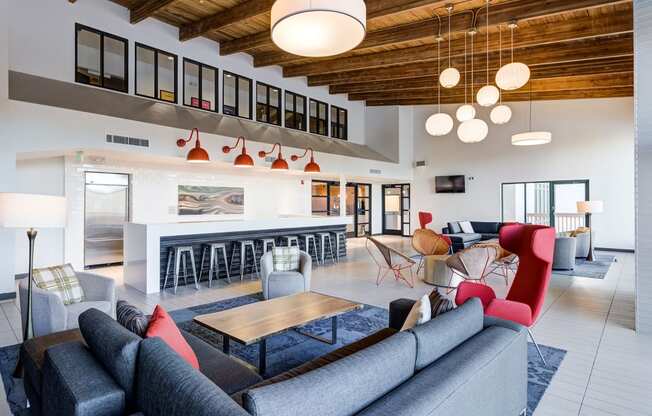 a living room with couches and chairs and a kitchen at Ashford Belmar Apartments, Lakewood, CO