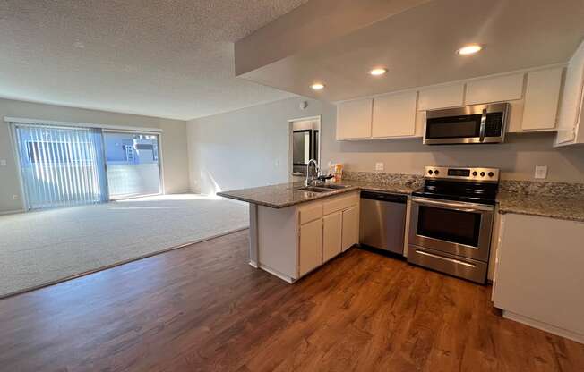 an empty kitchen with stainless steel appliances and a counter top