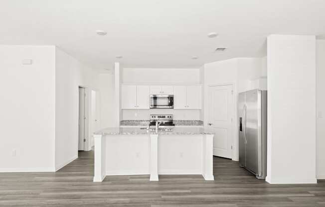 a kitchen with white cabinets and modern appliances