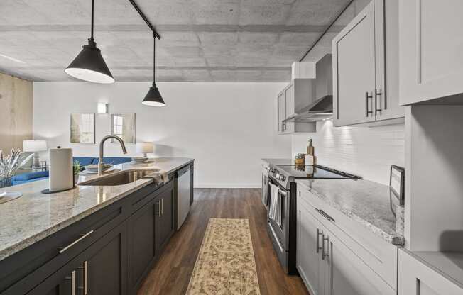 a kitchen with white cabinets and gray countertops  at The Icon, Richmond, 23230