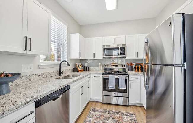 A kitchen with white cabinets and stainless steel appliances.