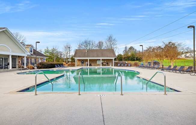 A large swimming pool with a diving board in the middle of a residential area.