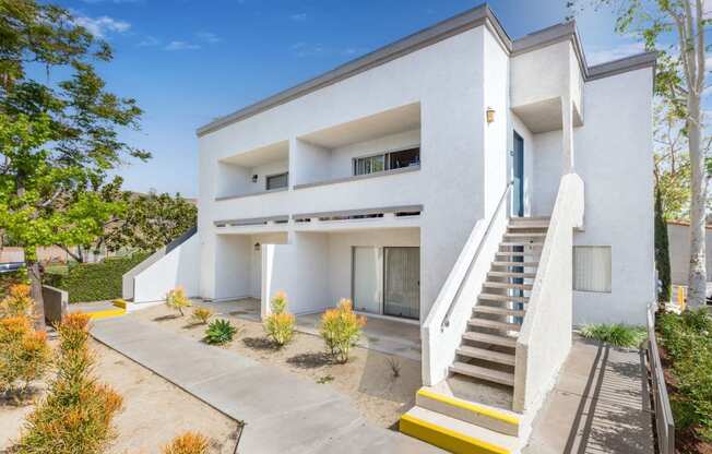 a white building with stairs and a blue door