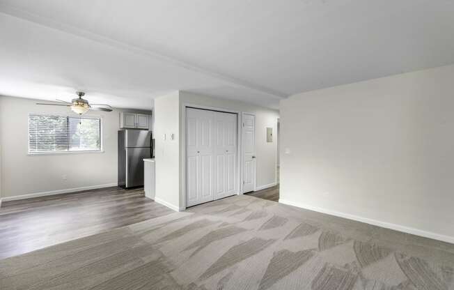 a living area with carpeting and a ceiling fan at Swiss Gables Apartment Homes, Kent, 98032