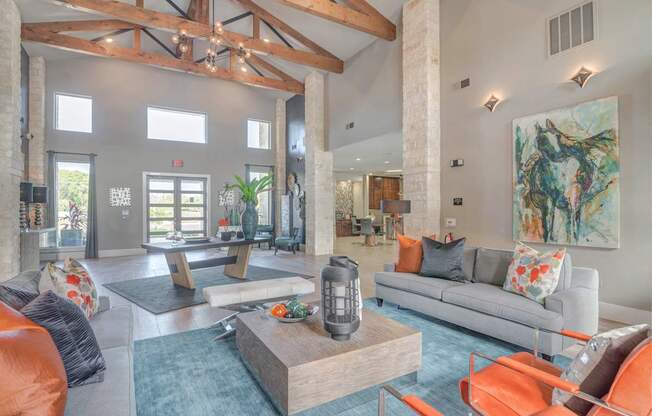 A living room with a grey couch and orange chairs.