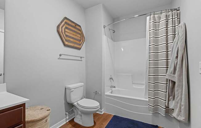 A white toilet sits next to a bathtub in a bathroom.