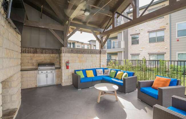A patio with a couch, chairs, and a table.