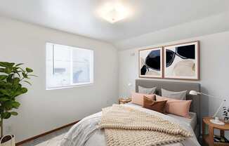A bedroom with a bed, pillows, a plant, and a painting on the wall at Shiloh Glen Apartments in Billings, MT.