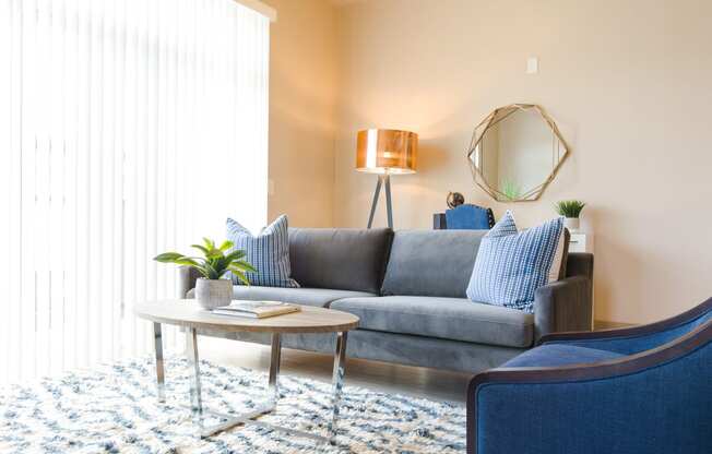 a living room with a gray couch and blue chairs