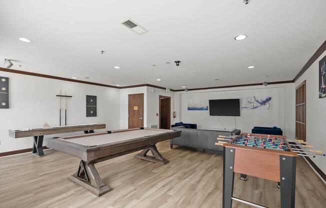 A room with a foosball table and air hockey table.