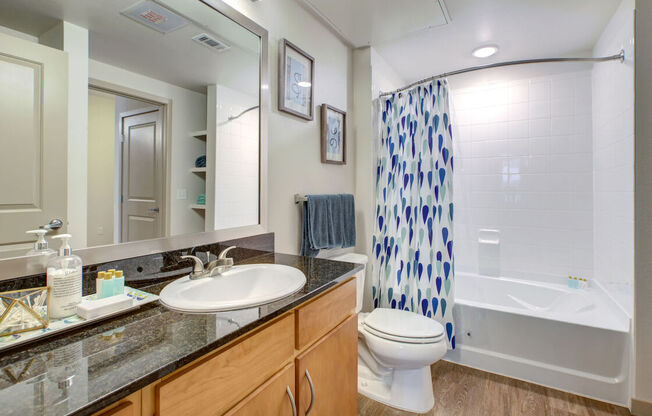 A bathroom with a white toilet, sink, and shower.