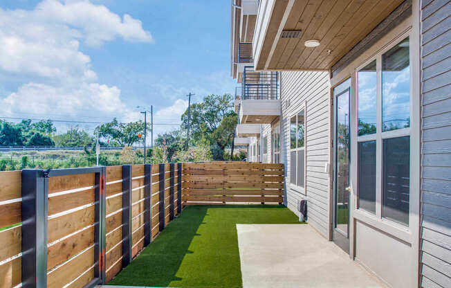 the patio of a home with a view of the yard and a balcony