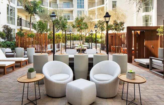 A patio with white chairs and tables.