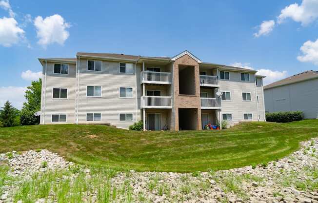 an apartment building on a hill with grass