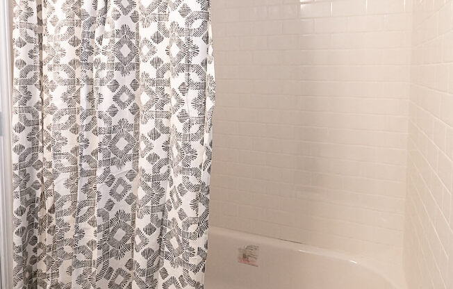 a bathroom with a tub and a shower curtain