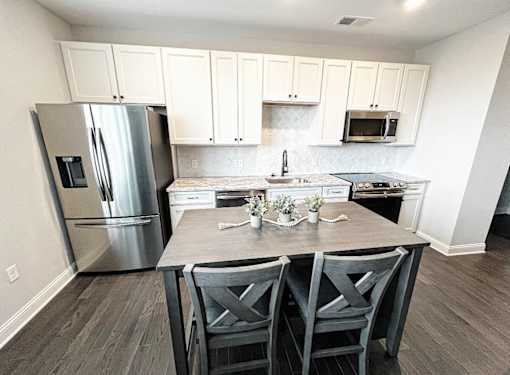 a kitchen with white cabinets and stainless steel appliances at Fairfax, Grandview, OH, 43212