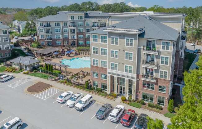 an aerial view of a large apartment complex with a swimming pool and parking lot