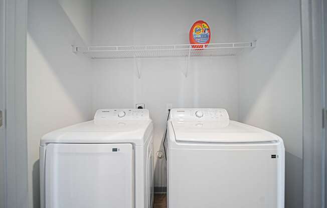 Two white washing machines in a laundry room.