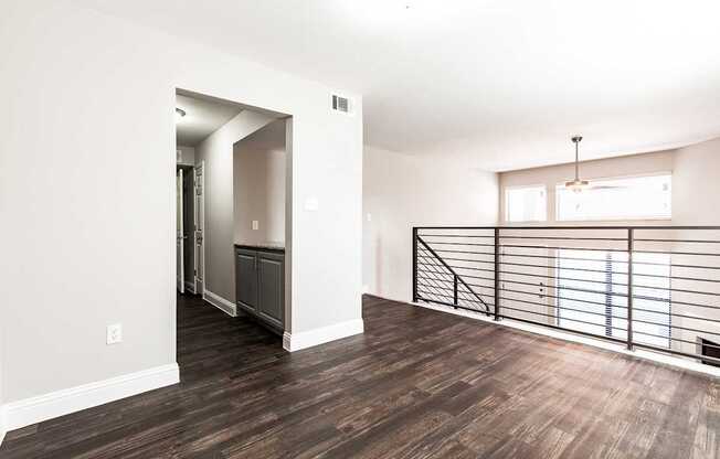 A4 apartment dining room next to kitchen with a metal railing overlooking living room and entrance at Vine Apartments in Arlington, TX