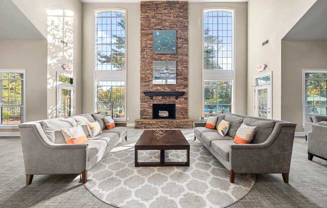 a living room with couches and a table in front of a fireplace