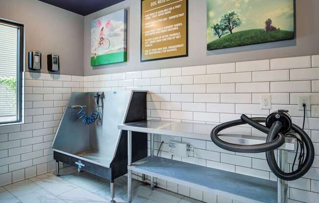 A cleaning station with a hose and a sign on the wall.