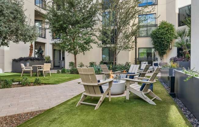 a patio with a table and chairs in front of an apartment building