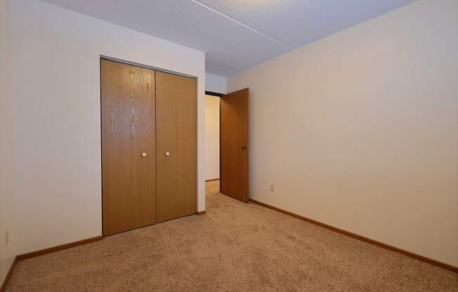 a bedroom with a closet and a door to a hallway at France, Fargo, 58103