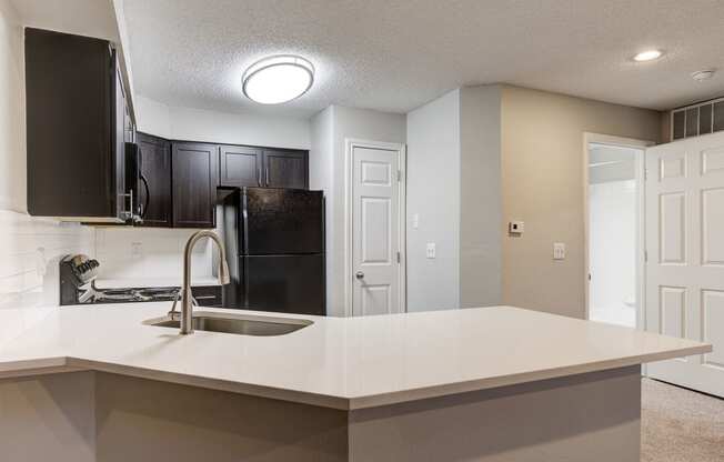 an empty kitchen with a sink and a refrigerator at Ashford Belmar Apartments, Colorado, 80226