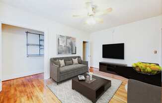 living area with sofa, coffee table, hardwood floors and ceiling fan at 1818 riggs apartments in washington dc