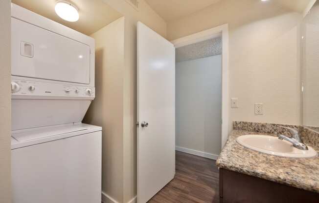 a kitchen with a washer and dryer and a sink and a laundry room