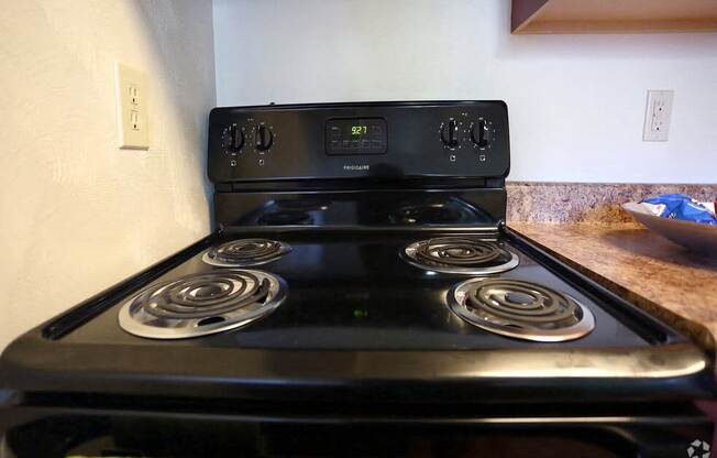 a black stove with four burners in a kitchen