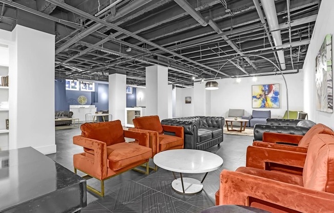 A room with orange chairs and a black table.