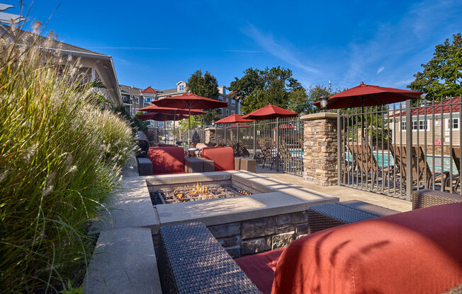 A patio with red umbrellas and a grill at Vermella Lyndhurst apartments, New Jersey, 07071