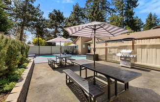 Resident Picnic Area with Picnic Tables and Striped Umbrellas at Park 210 Apartment Homes, Edmonds, WA, 98026